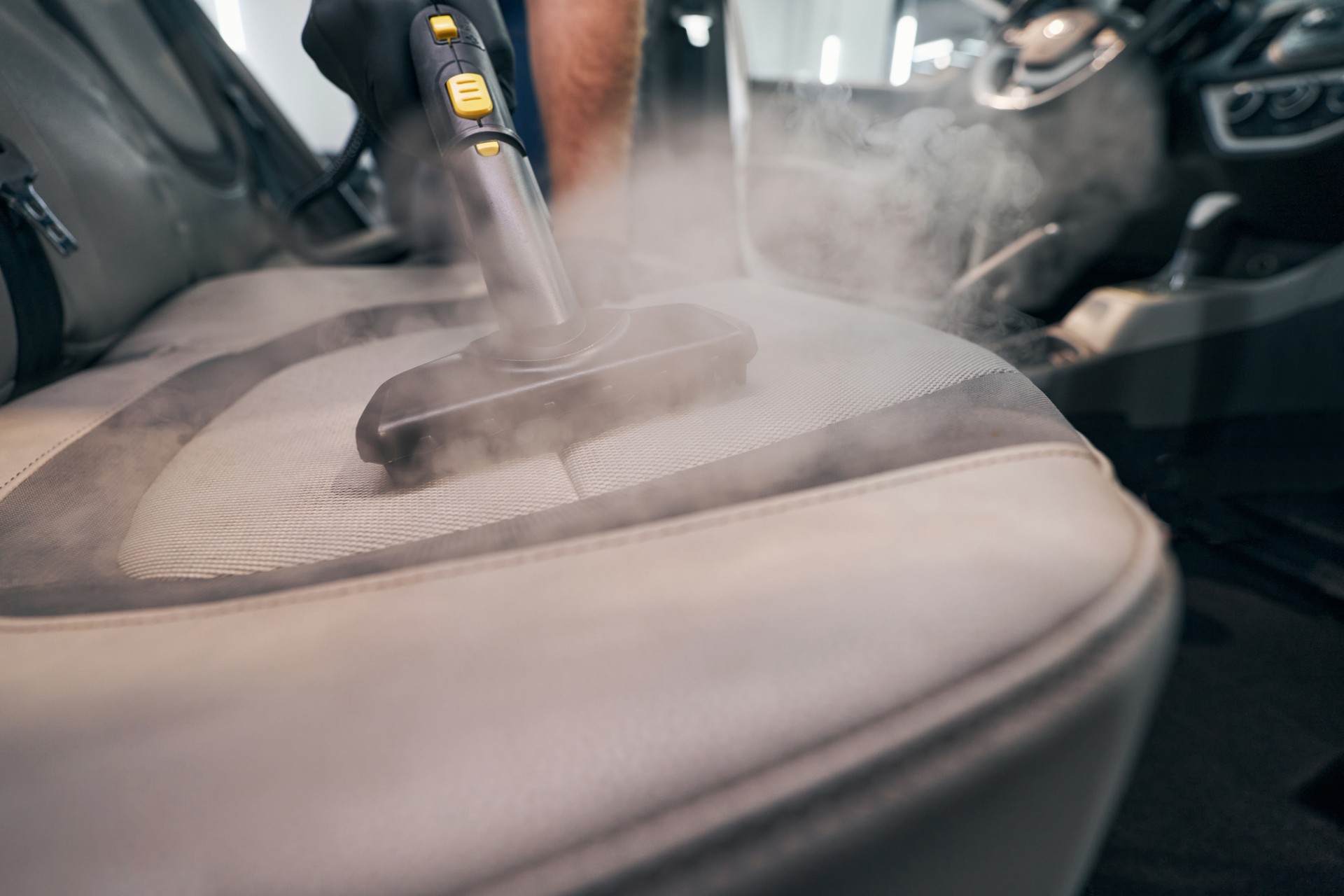 Lavage de siège professionnel avec gros plan de nettoyeur vapeur. Détail de la cabine de voiture